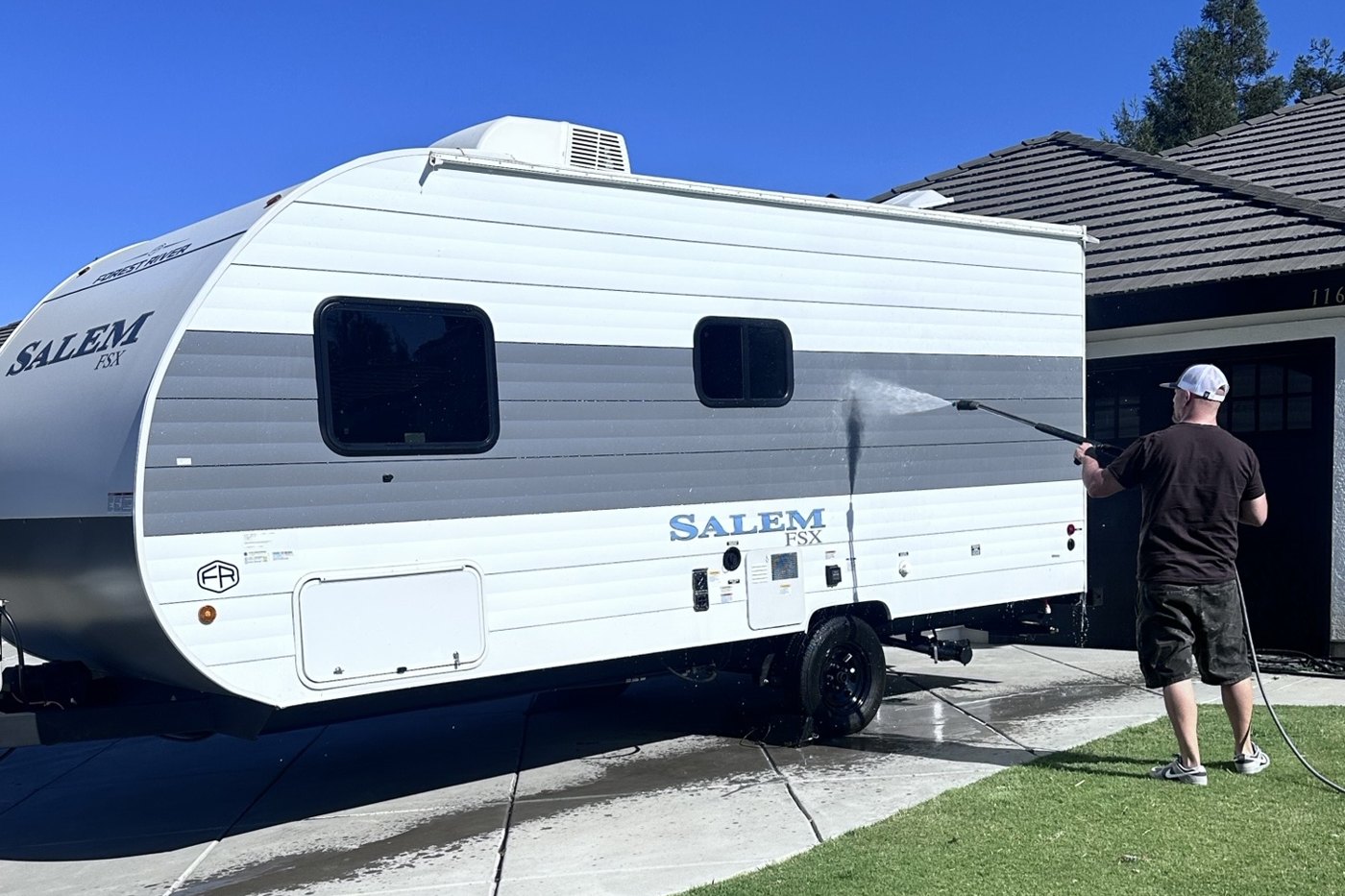 Powered H2O washing the exterior of a Salem travel trailer